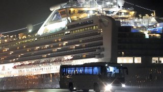 A bus with passengers believed to be U.S. citizens drives away from the Diamond Princess cruise ship, operated by Carnival Corp., docked in Yokohama, Japan, on Monday, Feb. 17, 2020.