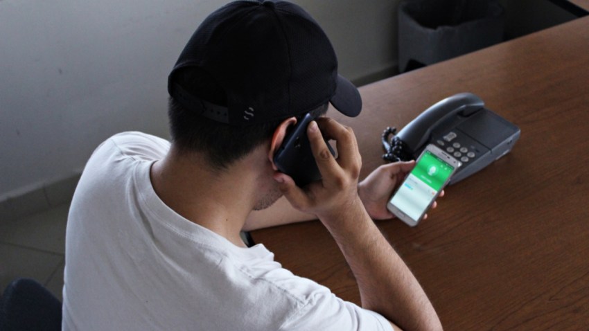 Hombre usa varios teléfonos móviles.