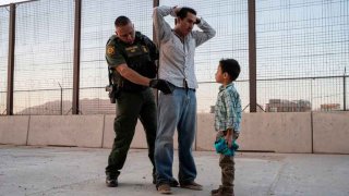 José, de 27 años, con su hijo José Daniel, de 6, es registrado por el agente de Aduanas y Protección Fronteriza de EEUU, Frank Pino, el 16 de mayo de 2019, en El Paso, Texas.