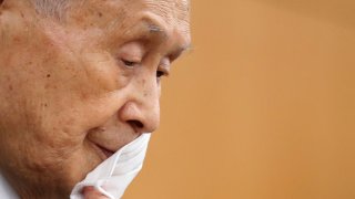 El entonces presidente de Tokio 2020, Yoshiro Mori, se quita la mascarilla protectora mientras asiste a una conferencia de prensa en Tokio el 4 de febrero de 2021.