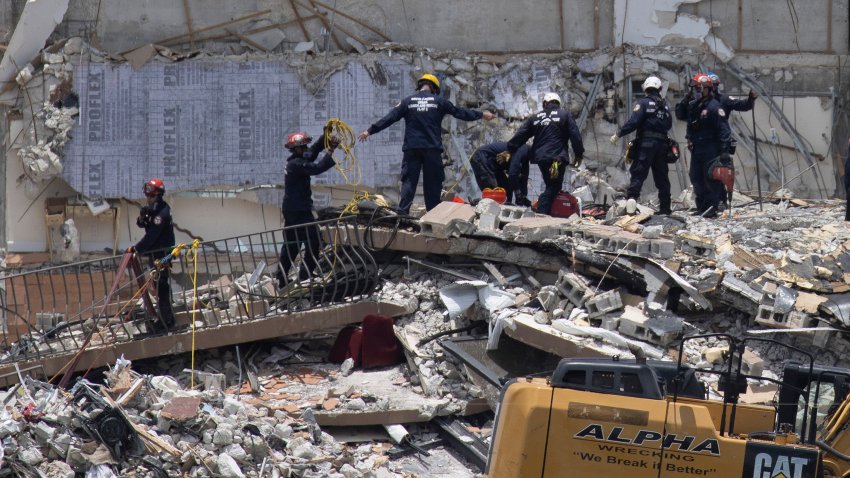 SURFSIDE, FLORIDA – JUNE 26: Members of the South Florida Urban Search and Rescue team look for possible survivors in the partially collapsed 12-story Champlain Towers South condo building on June 26, 2021 in Surfside, Florida. Over 150 people are being reported as missing as search-and-rescue efforts continue with rescue crews from across Miami-Dade and Broward counties. (Photo by Joe Raedle/Getty Images)