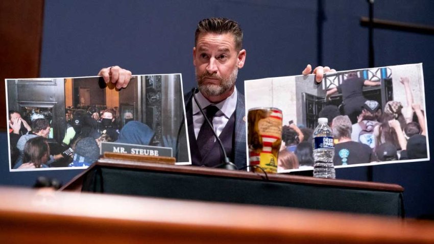 WASHINGTON, DC – OCTOBER 21: Rep. Greg Steube (R-FL) holds a photo from the January 6 attack on the Capitol (L) and a recent protest at the Interior Department (R) as he questions U.S. Attorney General Merrick Garland at a House Judiciary Committee hearing at the U.S. Capitol on October 21, 2021 in Washington, DC. Garland fielded many questions regarding first amendment issues related to school board meetings and efforts to prevent violence against public officials. (Photo by Greg Nash-Pool/Getty Images)