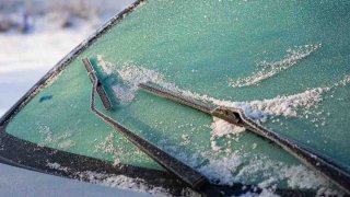 Nieve cubre parabrisas de un carro.