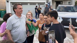 El expresidente brasileño Jair Bolsonaro posa para fotos con sus seguidores fuera de la casa en la que se hospeda el 22 de enero de 2023 en Kissimmee, Florida.