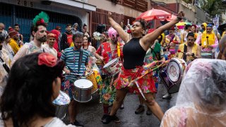 Integrantes de la comparsa callejera 'Saia de Chita' fueron registrados al celebrar, bajo la lluvia, el domingo de carnaval, en de la ciudad de Sao Paulo, Brasil.