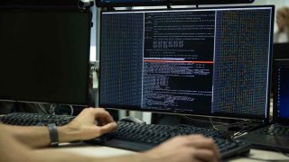 Un agente de ciberseguridad verifica los datos en una computadora.