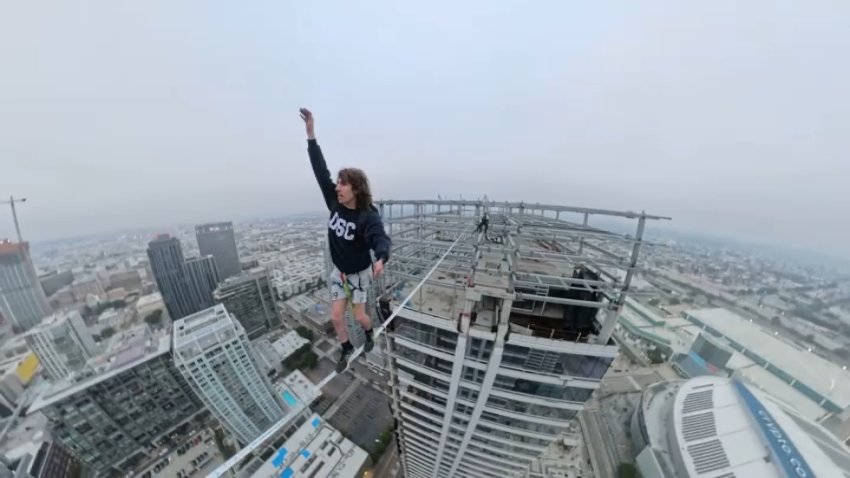 Ben Schneider uses a slackliner to walk 80 feet between downtown Los Angeles' infamous "Graffiti Towers."