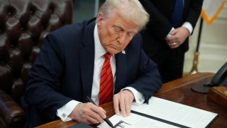 El presidente Donald Trump, firma una de las órdenes ejecutivas.