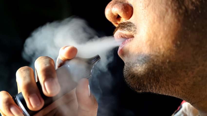 Portrait of man smoking an electronic cigarette at nighttime