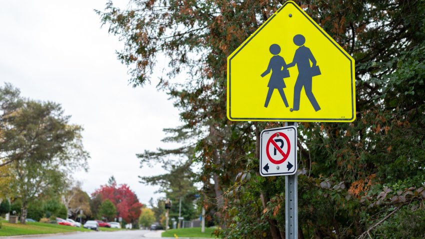 Yellow school crossing ahead sign on road near a school zone