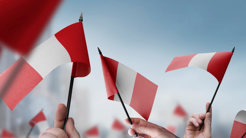Peru flags in their hands on a blurred urban background. The photo illustration was created without the use of artificial intelligence, only using Photoshop.