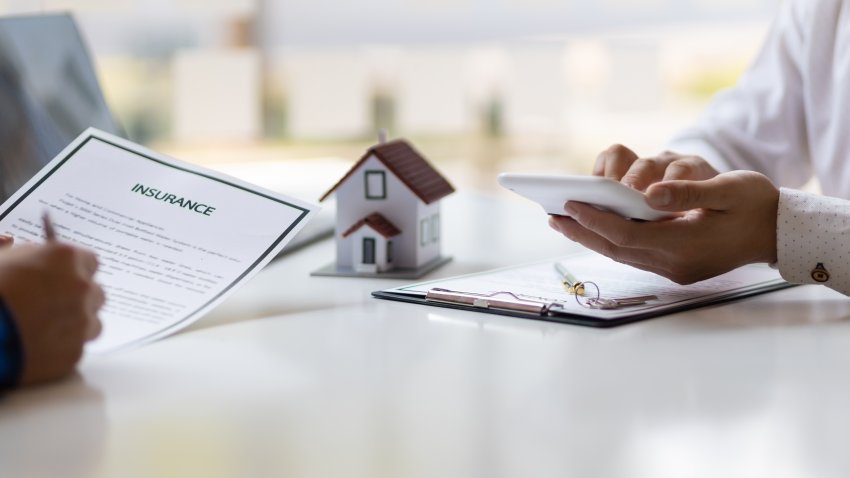 Real estate agents negotiate the terms of the home purchase contract and sign the contract legally. Home insurance concept.